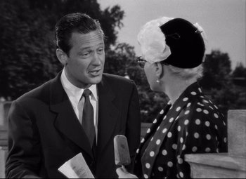Movie still from “Born Yesterday” (1950), directed by George Cukor – An older woman talking to an older man in a suit and tie; Close Up shot, Over the shoulder angle