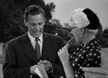 Movie still from “Born Yesterday” (1950), directed by George Cukor – An older man and a younger woman laughing together; Medium shot, Over the shoulder angle
