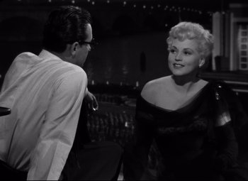 Movie still from “Born Yesterday” (1950), directed by George Cukor – A man and a woman talking to each other; Medium shot, Over the shoulder angle