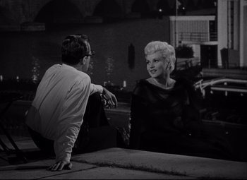 Movie still from “Born Yesterday” (1950), directed by George Cukor – A black and white photo of a man and a woman; Medium shot, High angle