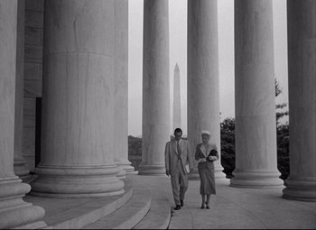 Movie still from “Born Yesterday” (1950), directed by George Cukor – A man and a woman are walking in front of the washington monument; Wide shot, Low angle