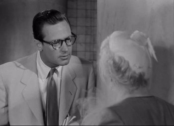 Movie still from “Born Yesterday” (1950), directed by George Cukor – A man in a suit and tie talking to a woman; Close Up shot, Over the shoulder angle