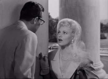 Movie still from “Born Yesterday” (1950), directed by George Cukor – A man and a woman talking to each other; Medium shot, High angle