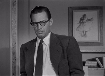 Movie still from “Born Yesterday” (1950), directed by George Cukor – A black and white photo of a man in a suit and tie; Close Up shot, Over the shoulder angle