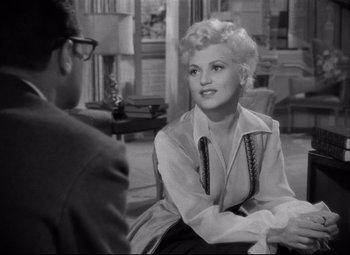 Movie still from “Born Yesterday” (1950), directed by George Cukor – An old black and white photo of a man and a woman; Medium shot, Over the shoulder angle