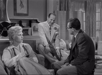 Movie still from “Born Yesterday” (1950), directed by George Cukor – A group of people sitting around a living room together; Wide shot, High angle