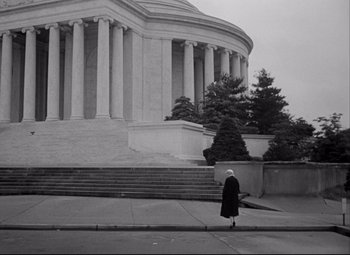 Movie still from “Born Yesterday” (1950), directed by George Cukor – An older woman walking down the street in front of a building; Extreme Wide shot, Low angle