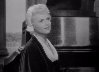 Movie still from “Born Yesterday” (1950), directed by George Cukor – An old black and white photo of a woman; Close Up shot, Low angle