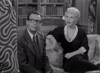 Movie still from “Born Yesterday” (1950), directed by George Cukor – An older man and a younger woman sitting on a couch; Medium shot, Low angle