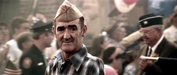 Movie still from “Born on the Fourth of July” (1989), directed by Oliver Stone – An older man wearing a hat and a plaid shirt; Close Up shot, Low angle