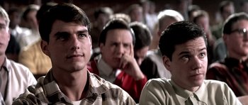 Movie still from “Born on the Fourth of July” (1989), directed by Oliver Stone – A group of people sitting in a room; Close Up shot, Over the shoulder angle