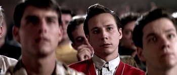 Movie still from “Born on the Fourth of July” (1989), directed by Oliver Stone – A man in a red jacket is looking at the camera; Close Up shot, Over the shoulder angle