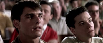 Movie still from “Born on the Fourth of July” (1989), directed by Oliver Stone – A group of young men sitting in front of each other in a room; Close Up shot, Over the shoulder angle
