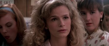 Movie still from “Born on the Fourth of July” (1989), directed by Oliver Stone – A person with curly hair; Close Up shot, Over the shoulder angle