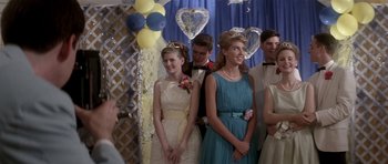 Movie still from “Born on the Fourth of July” (1989), directed by Oliver Stone – A group of young people standing next to each other in formal wear; Medium shot, Low angle
