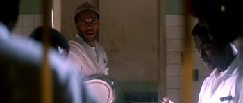 Movie still from “Born on the Fourth of July” (1989), directed by Oliver Stone – A man holding a bowl in a room; Close Up shot, Over the shoulder angle