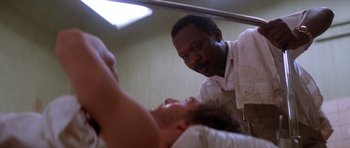 Movie still from “Born on the Fourth of July” (1989), directed by Oliver Stone – A man standing next to another man in a room; Close Up shot, Low angle