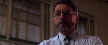 Movie still from “Born on the Fourth of July” (1989), directed by Oliver Stone – A person wearing glasses and a tie; Close Up shot, Low angle