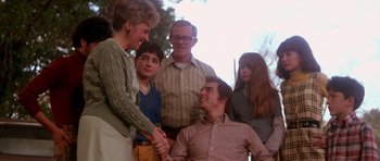 Movie still from “Born on the Fourth of July” (1989), directed by Oliver Stone – A group of people standing next to each other; Medium shot, Over the shoulder angle