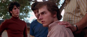 Movie still from “Born on the Fourth of July” (1989), directed by Oliver Stone – Two young men standing next to each other in a park; Close Up shot, Over the shoulder angle