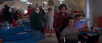 Movie still from “Born on the Fourth of July” (1989), directed by Oliver Stone – A group of people standing in a room; Medium shot, Over the shoulder angle