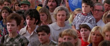 Movie still from “Born on the Fourth of July” (1989), directed by Oliver Stone – A group of people standing around each other in a crowd; Medium shot, High angle