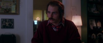 Movie still from “Born on the Fourth of July” (1989), directed by Oliver Stone – A man with a beard and mustache wearing a red sweater; Close Up shot, Low angle