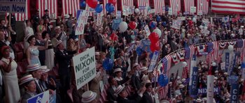 Movie still from “Born on the Fourth of July” (1989), directed by Oliver Stone – A large crowd of people are gathered in a stadium; Extreme Wide shot, High angle