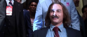 Movie still from “Born on the Fourth of July” (1989), directed by Oliver Stone – A person wearing a suit and tie; Close Up shot, Low angle