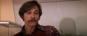Movie still from “Born on the Fourth of July” (1989), directed by Oliver Stone – A person wearing a shirt with a mustache; Close Up shot, Low angle