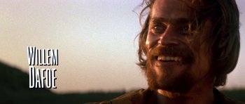 Movie still from “Born on the Fourth of July” (1989), directed by Oliver Stone – A man with a beard smiling for the camera; Close Up shot, Low angle