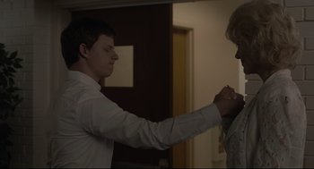 Movie still from “Boy Erased” (2018), directed by Joel Edgerton – A young man adjusting the collar of a young man's dress shirt; Medium shot, Over the shoulder angle