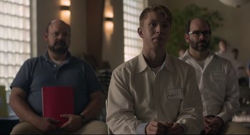 Movie still from “Boy Erased” (2018), directed by Joel Edgerton – A man sitting in front of two other men in a room; Medium shot, Over the shoulder angle