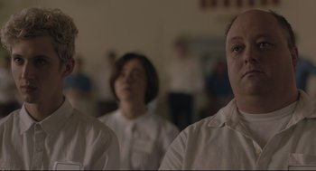 Movie still from “Boy Erased” (2018), directed by Joel Edgerton – A group of people standing in a room; Close Up shot, Over the shoulder angle