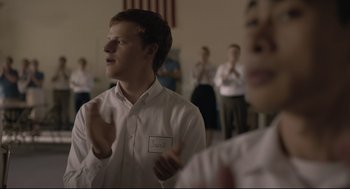 Movie still from “Boy Erased” (2018), directed by Joel Edgerton – A young man clapping in front of a group of people; Medium shot, Over the shoulder angle