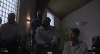 Movie still from “Boy Erased” (2018), directed by Joel Edgerton – Three people are sitting in a living room together; Medium shot, Low angle