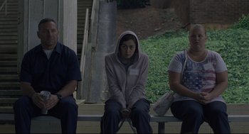 Movie still from “Boy Erased” (2018), directed by Joel Edgerton – A group of people sitting next to each other on top of a bench; Medium shot, High angle