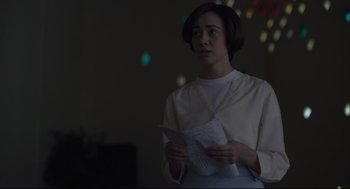 Movie still from “Boy Erased” (2018), directed by Joel Edgerton – A woman standing in a room holding a piece of paper in her hands; Medium shot, Over the shoulder angle