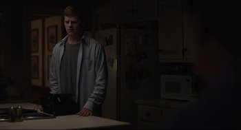 Movie still from “Boy Erased” (2018), directed by Joel Edgerton – A man standing in a kitchen next to a counter; Medium shot, Over the shoulder angle
