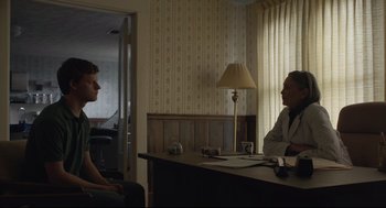 Movie still from “Boy Erased” (2018), directed by Joel Edgerton – Two people sitting at a table in a room; Wide shot, Over the shoulder angle