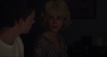 Movie still from “Boy Erased” (2018), directed by Joel Edgerton – A woman with blonde curly hair is looking at the camera; Close Up shot, Over the shoulder angle