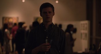 Movie still from “Boy Erased” (2018), directed by Joel Edgerton – A young man holding a glass in a dark room; Medium shot, Over the shoulder angle