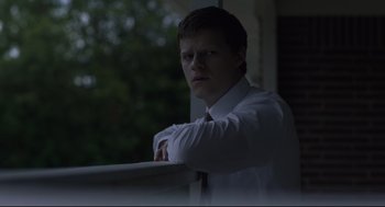 Movie still from “Boy Erased” (2018), directed by Joel Edgerton – A man in a white shirt and a red tie leaning on a railing; Close Up shot, Low angle