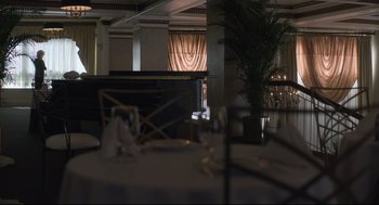 Movie still from “Boy Erased” (2018), directed by Joel Edgerton – A room filled with tables and chairs and a piano; Wide shot, High angle