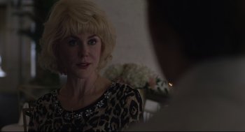 Movie still from “Boy Erased” (2018), directed by Joel Edgerton – A woman in a leopard print dress looking at a man in a black suit; Close Up shot, Over the shoulder angle