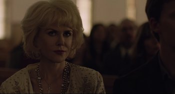 Movie still from “Boy Erased” (2018), directed by Joel Edgerton – A woman with blonde hair and a cross necklace; Close Up shot, Over the shoulder angle