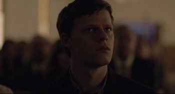 Movie still from “Boy Erased” (2018), directed by Joel Edgerton – A young man looking into the distance in a dark room; Close Up shot, Over the shoulder angle