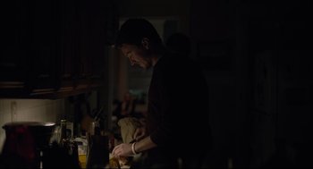 Movie still from “Boy Erased” (2018), directed by Joel Edgerton – A man standing in a kitchen preparing a meal; Medium shot, Over the shoulder angle