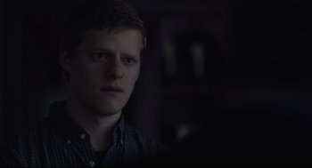 Movie still from “Boy Erased” (2018), directed by Joel Edgerton – A young man in a dark room looking at the camera; Close Up shot, Over the shoulder angle