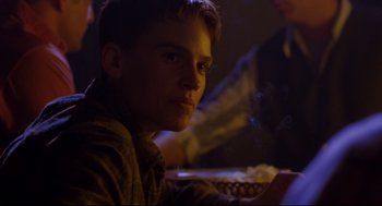 Movie still from “Boys Don't Cry” (1999), directed by Kimberly Peirce – A man sitting at a table with a plate of food; Close Up shot, Over the shoulder angle